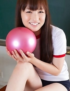 Maho Kiruma in sports equipment plays with ball on desk