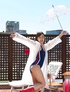 Kana Yuuki in bathsuit plays with umbrella in the balcony
