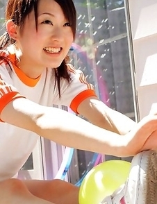 Naoko Sawano in sports outfit plays with balls in garden